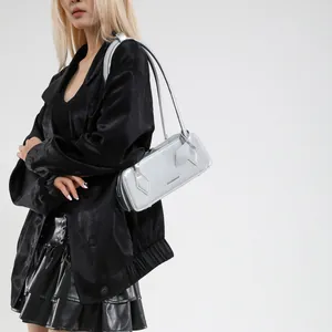 Silver patent leather baguette bag with metal finish worn by model on white background