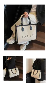 Detalle del bolso tote de lona con ribete de cuero negro y estampado Paris en varios ángulos