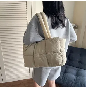 Detail of beige quilted down tote bag with soft padded straps and large capacity