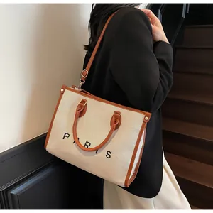 Primer plano de bolso tote de lona con bordes de cuero y logo de París en escalera