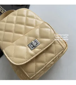 Détail du cuir matelassé beige et du fermoir rotatif en métal argenté du sac