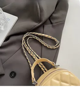 Détail du sac en cuir matelassé beige avec bandoulière chaîne et poignée ronde