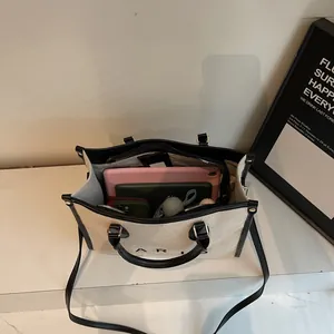 Bolso tote grande de lona beige con ribetes de cuero negro y amplio espacio interior útil