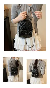 Détail du sac à dos en cuir matelassé noir avec fermoir rotatif et chaîne