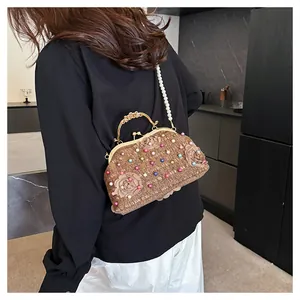 Dettaglio borsa in tweed con tracolla di perle, decori floreali e telaio dorato
