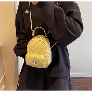 Macro detail of yellow quilted mini backpack with rhinestone studs and silver twist lock