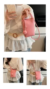 Detail of pink pebbled leather mini crossbody phone bag with knot decorative charm