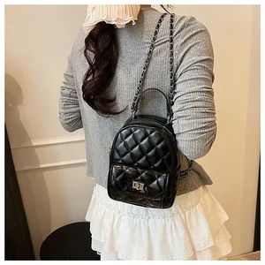 Détails du mini sac à dos matelassé noir avec texture en cuir brillant et chaîne argentée