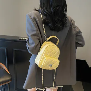 Bright yellow quilted mini backpack in shiny PU with silver chain straps and turn-lock