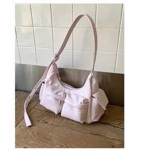 Detail der hellrosa Schultertasche mit Utility-Taschen und verstellbarem Gurt