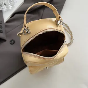 Sac à main matelassé jaune pastel en cuir PU avec bandoulière sur blazer gris