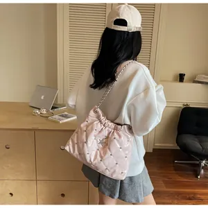 Pink quilted shoulder bag with silver star rivets and chain strap shown on a model