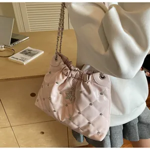 Detail of pink quilted shoulder bag with sparkling rhinestone star and chain strap