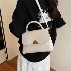 Chic white lychee-patterned crossbody bag with gold buckle and top handle for women