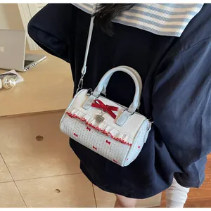 Détail du sac bowling blanc avec anses bleues et grand charm cœur en velours rouge