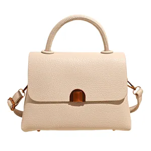 Elegant beige lychee grain leather handbag with bronze metal lock and top handle
