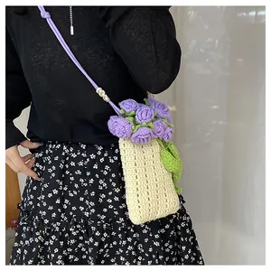 Detalle de bolso para móvil tejido a mano con rosas de ganchillo y cuentas madera