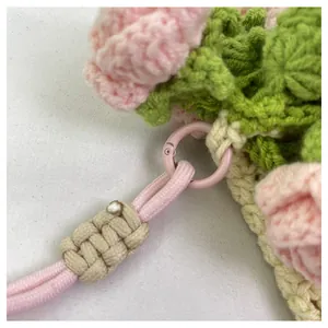 Detalle de bolso de flores tejido a mano rosa con textura de ganchillo y hebilla de metal