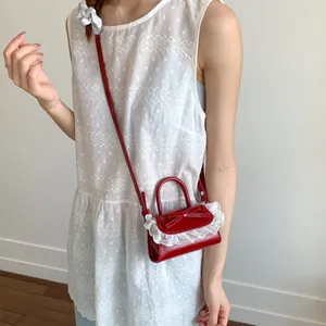 Elegant red bow handbag with white lace trim and shoulder strap for women