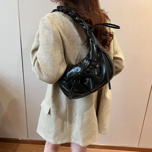 Fashionable black pleated shoulder bag with bow details and glossy hobo style finish