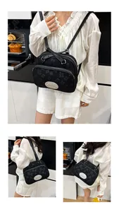 Détail du sac jacquard noir avec plaque métallique argentée et double fermeture éclair