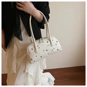 Detail of off-white shoulder bag with scattered pearls and star metal studs on leather
