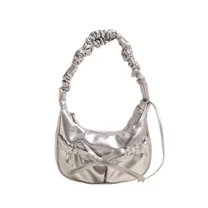 Metallic silver crescent shoulder bag with pleated handle and bow detail