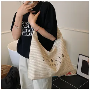 Vista dettagliata di una borsa tote in tessuto beige con scritte nere in casa