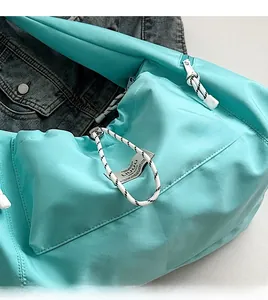 Dettaglio del tessuto in nylon verde menta resistente all'acqua con tirazip in corda bianca