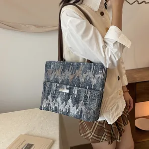Blue sequin geometric tote bag with brown straps styled for a retro commute look