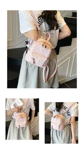 Detailed macro view of pink floral jacquard texture and golden hardware on mini backpack