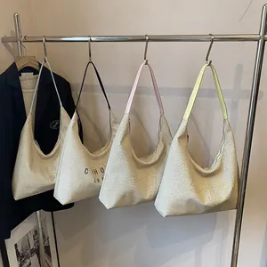 Borse a secchiello intrecciate alla moda in blu, rosa e giallo su uno stand espositivo