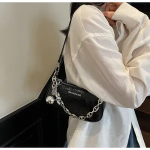 Detail of black wrinkled leather shoulder bag with silver chain and metal ball charm