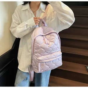 Close-up of light purple quilted backpack with heart pattern and satin finish texture