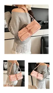 Detail der rosa matten Lederumhängetasche mit zwei Taschen und Schleifendekorationen