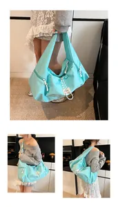 Vista dettagliata della borsa sottobraccio in nylon azzurro con cerniere intrecciate