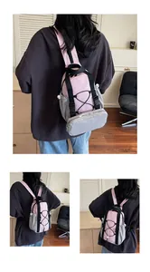 Macro detail of a pink and grey multi-pocket outdoor sports backpack with elastic cord