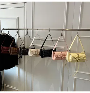 Detailansicht bunter Vintage-Schultertaschen mit Schleifendekor an einem Kleiderbügel
