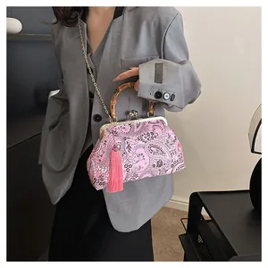 Détail du sac coquillage paisley rose avec poignée en bambou et chaîne dorée