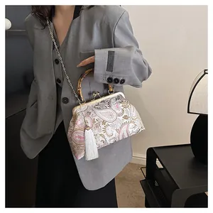 Détail du sac brodé à motif cachemire avec poignée en bambou et fermoir métallique