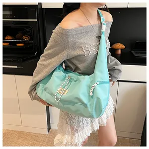 Dettaglio della borsa a spalla in nylon verde menta con coulisse e tracolla larga regolabile