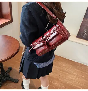 Detail der dunkelroten Lackleder-Umhängetasche mit Vintage-Schleifen und vielen Taschen