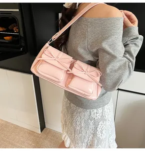Detail der rosa Lackledertasche mit Vordertaschen und süßer Schleifendekoration