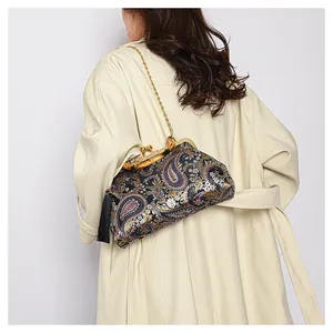 Détail du sac coquille brodé paisley avec poignée en bambou et chaîne dorée