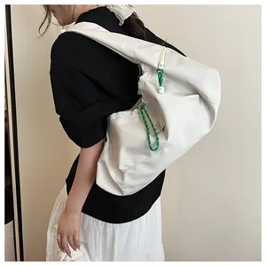Dettaglio di una borsa a spalla in nylon bianco con coulisse verde e grande capacità