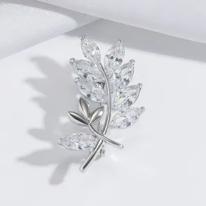 Élégante broche en argent en forme de blé avec zircons brillants sur fond de satin blanc