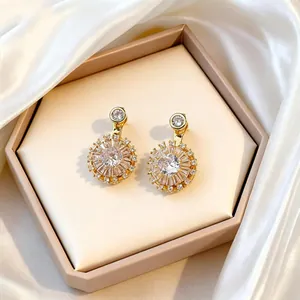 Detail of gold floral stud earrings with large central zircon and halo pavé diamonds