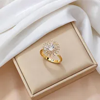 Close-up of a gold sunflower ring with sparkling zircon stones on white silk background