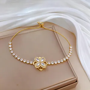 Detail of adjustable gold floral bracelet with sparkling zircon petals and slider clasp