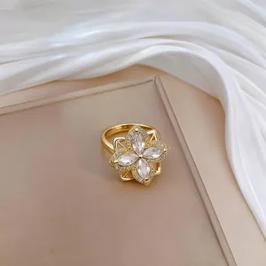 Close-up of golden clover ring with sparkling marquise-cut zircon stones and micro-pave